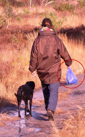 Walking the dog and holding their poopy in a bag